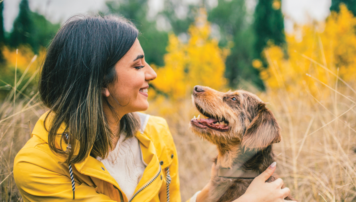 Girl in Yellow Jacket Smiling with Brown Dog