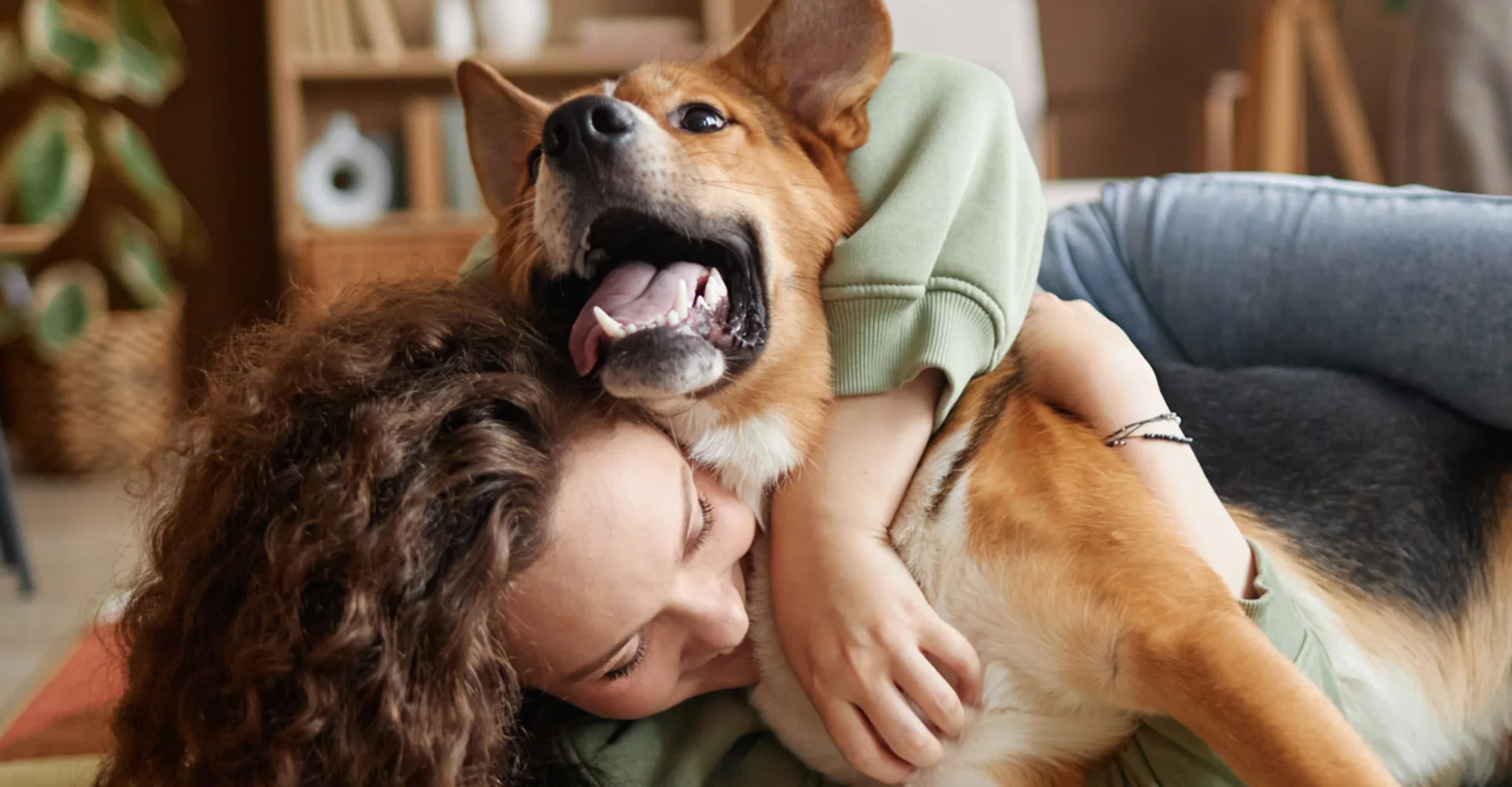 Woman hugging brown dog laying on floor