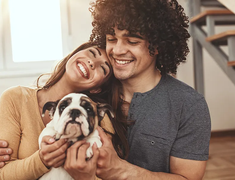 Photo of a happy couple holding a small dog