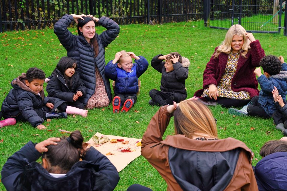 images/Children sitting outside in a circle wth teachers