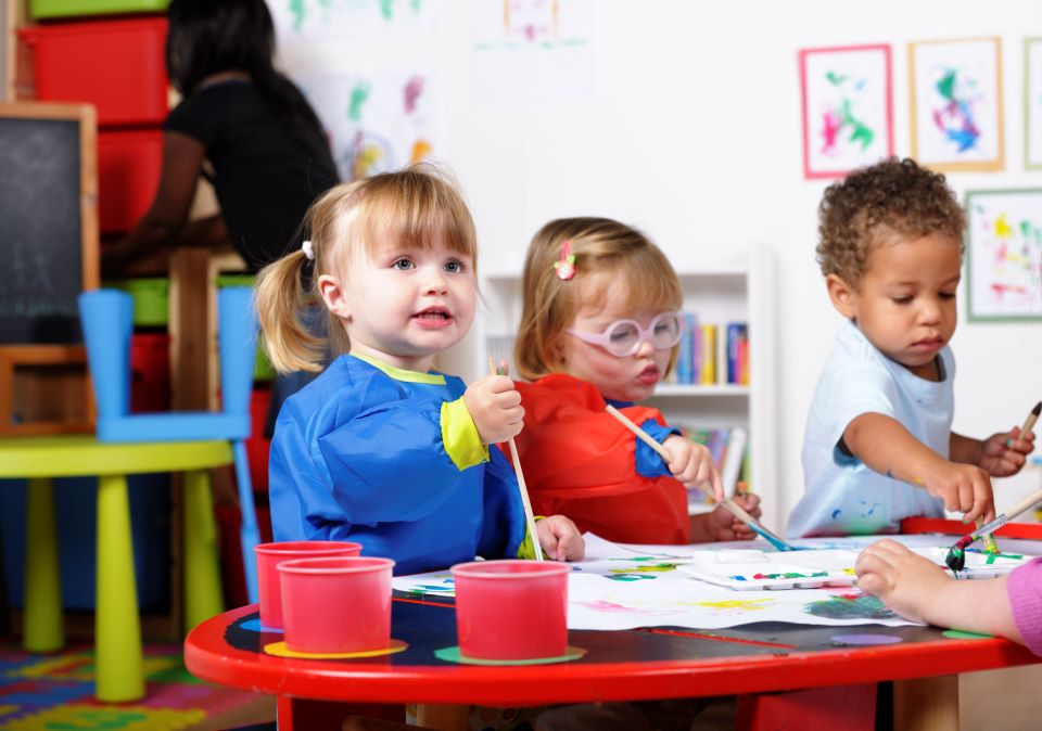 A group of toddlers painting.