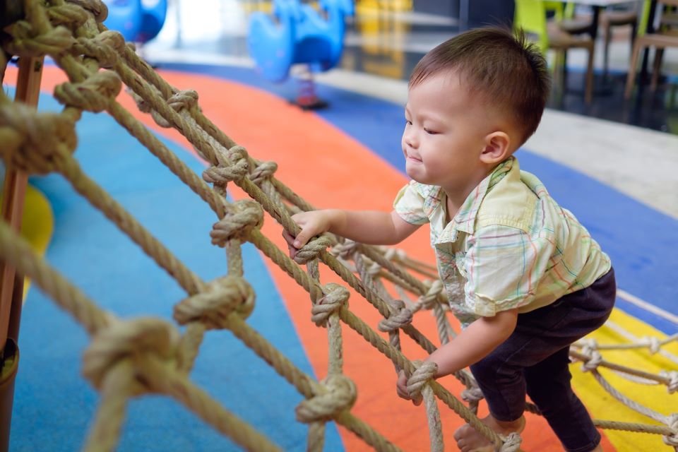 Toddler climbing a rope. 