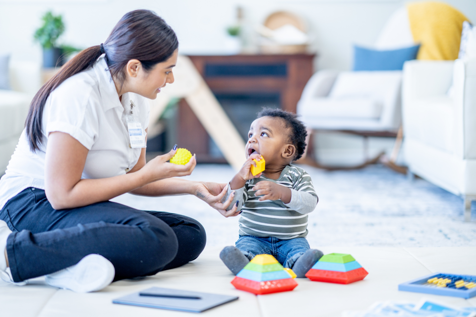 A practitioner and child playing on the floor together 