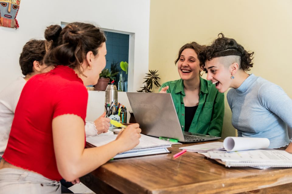 Group of practitioners sat round a table with a laptop 