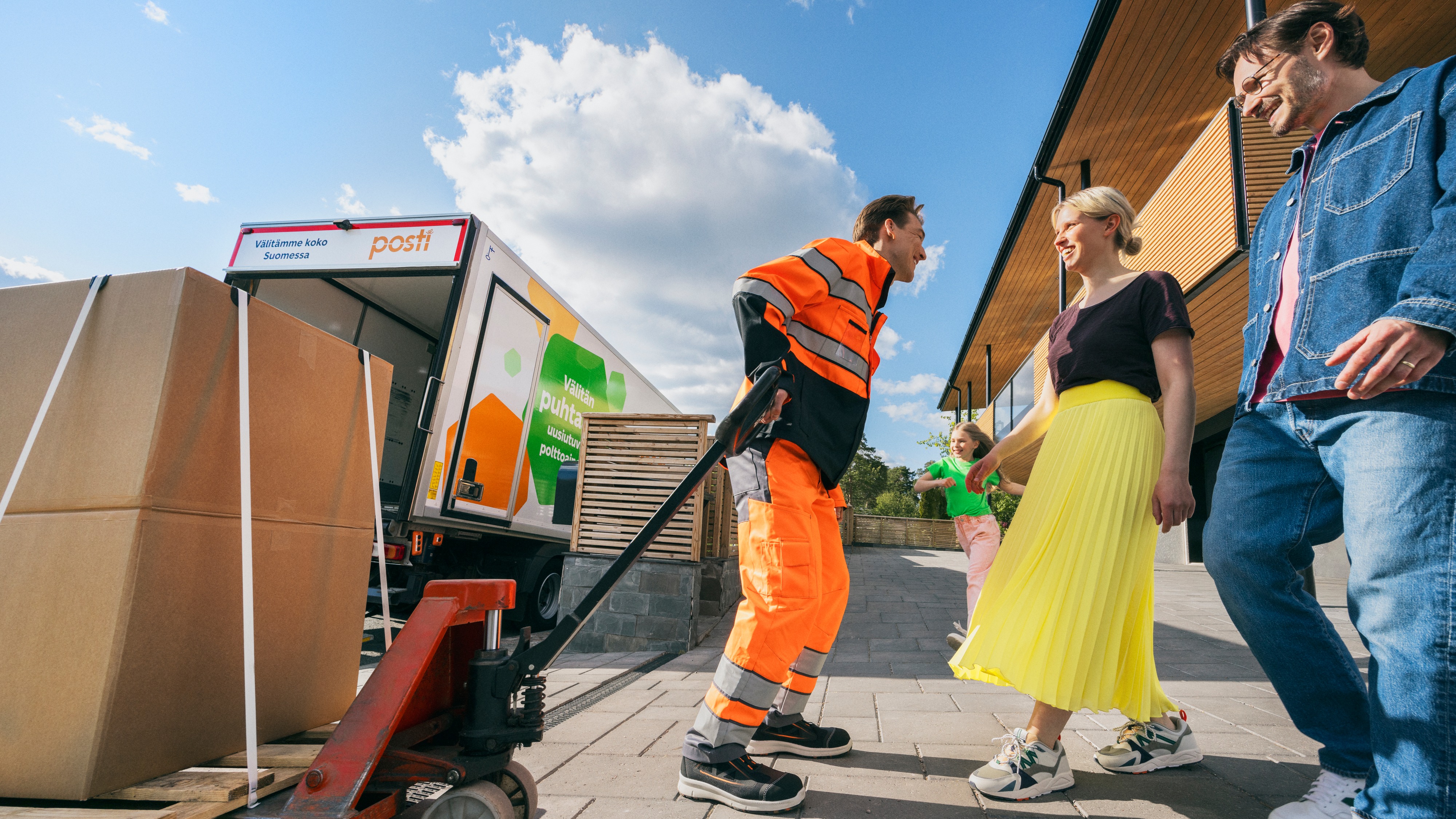 A Posti logistics worker delivers a large package to customers.
