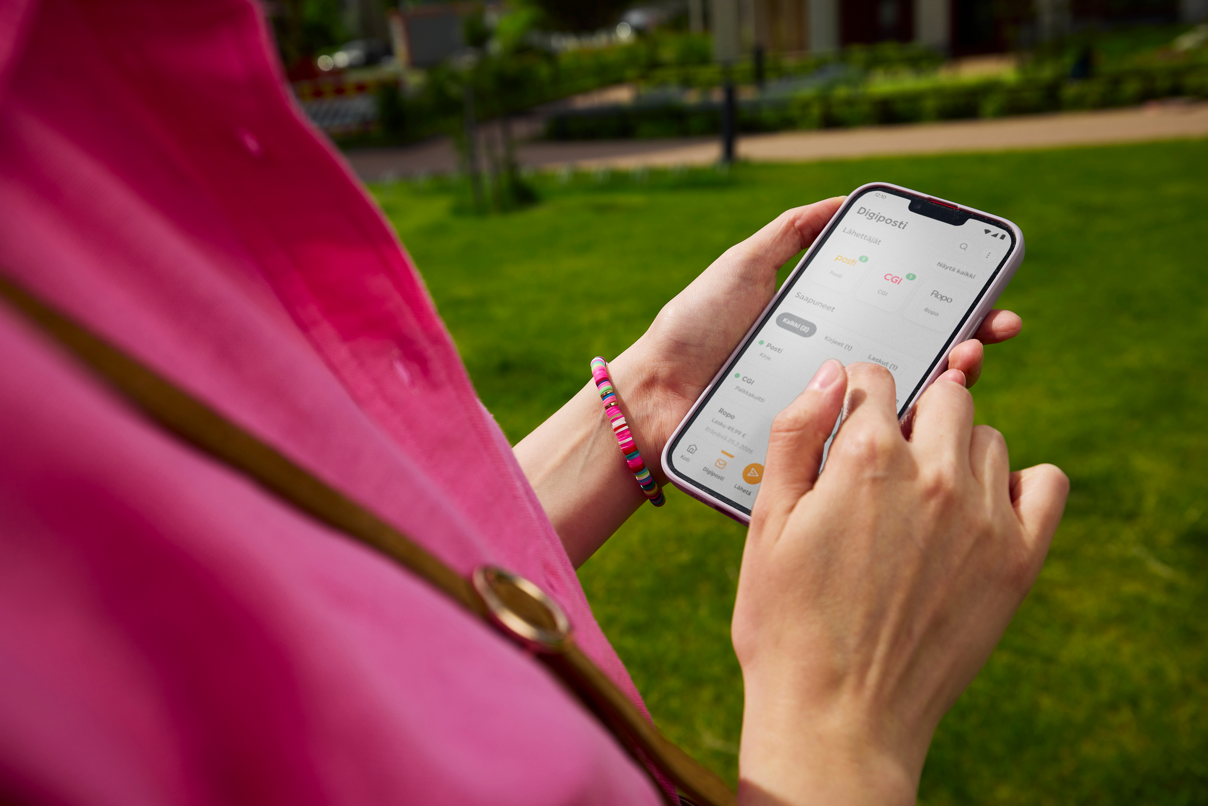 Person håller en mobiltelefon med Digipost i OmaPosti-appen öppen i en park