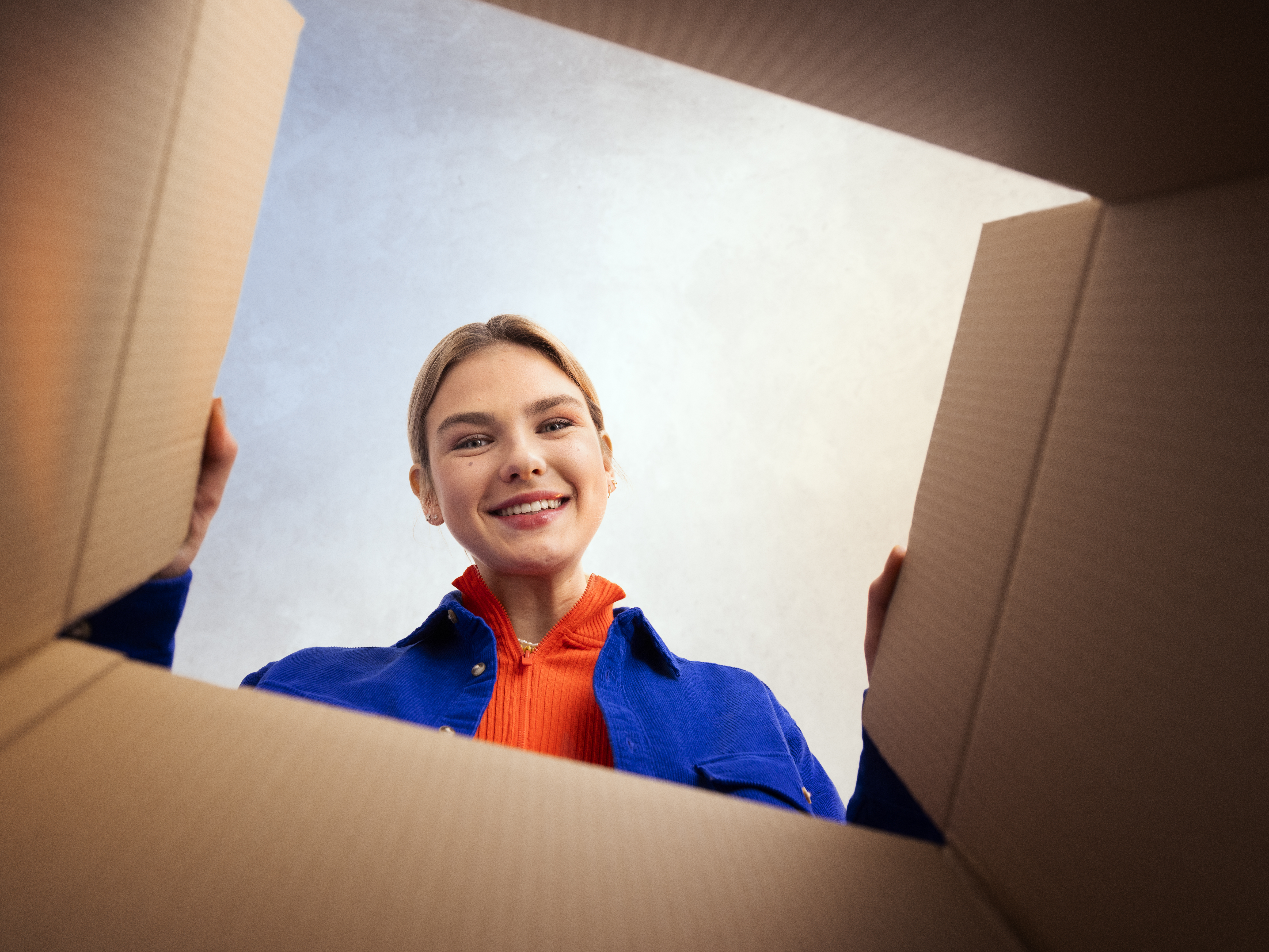 A woman looking into a cardboard box.