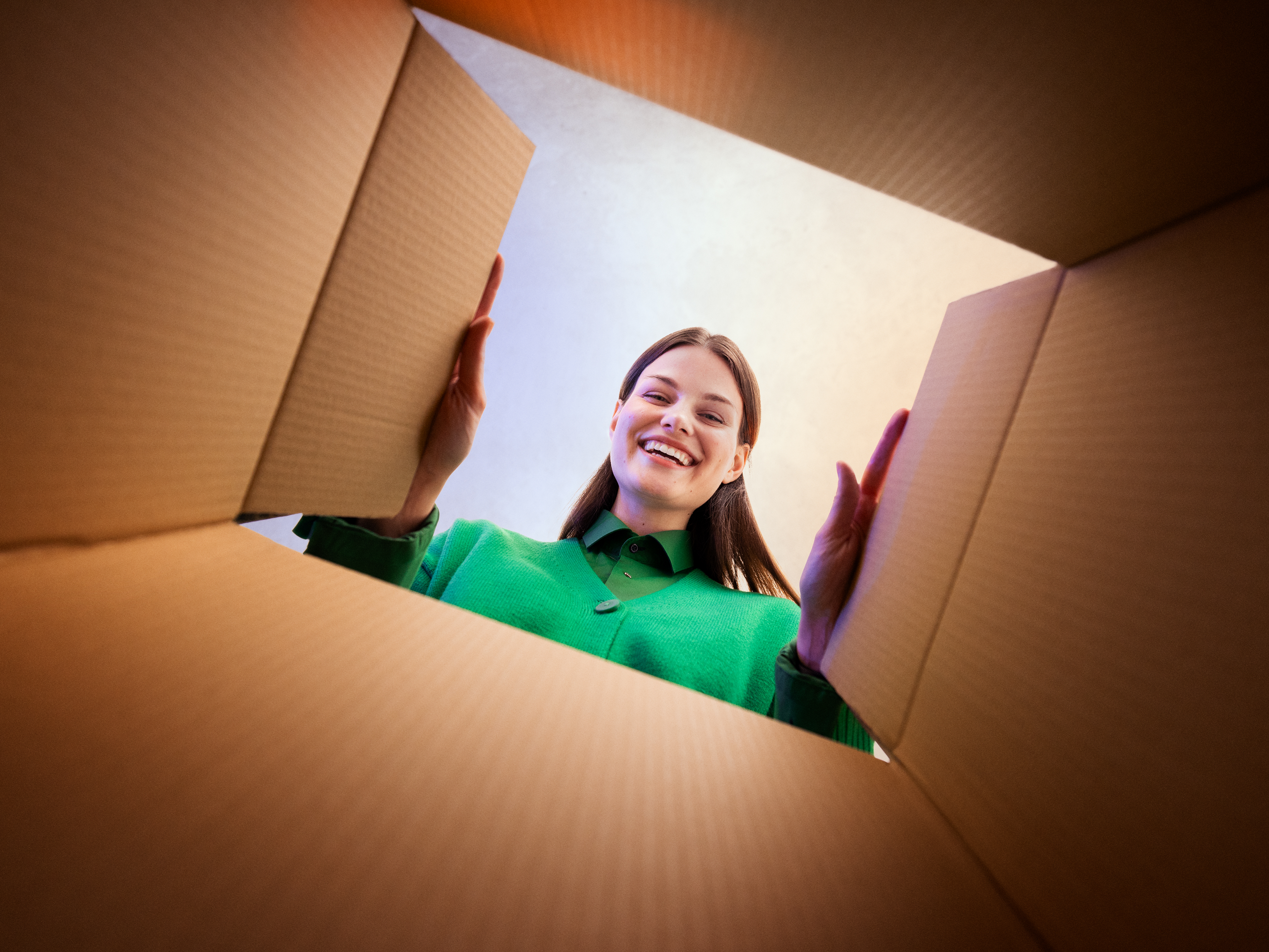 A woman looking into a cardboard box.