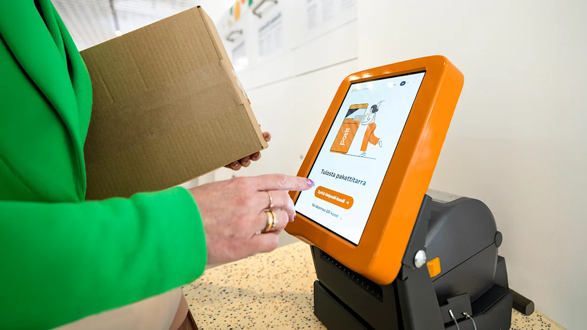 A person sends a parcel at a Posti self-service point using a parcel label printer.