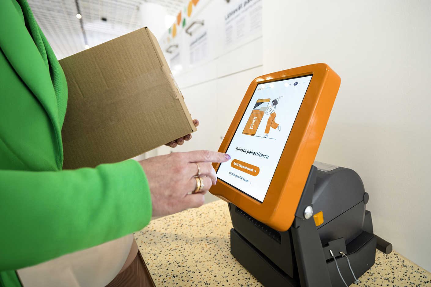 En person skickar ett paket vid Postis självbetjäningspunkt med en adressetikettskrivare.
