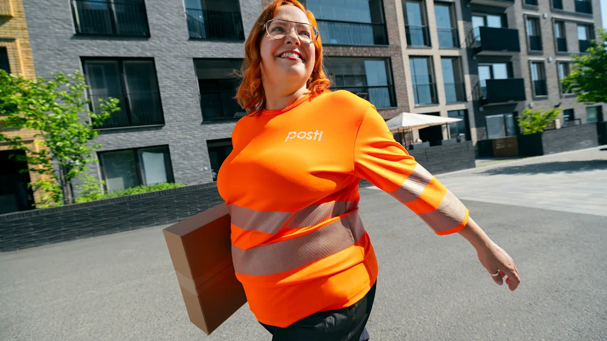 Hymyilevä Postin työntekijä kantaa pikkupakettia.