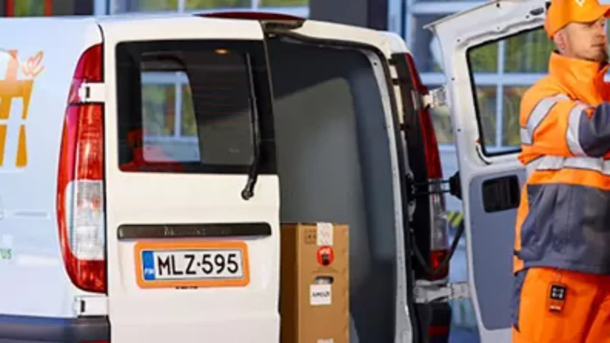Posti's personnel is transfering packages to the transportation van.
