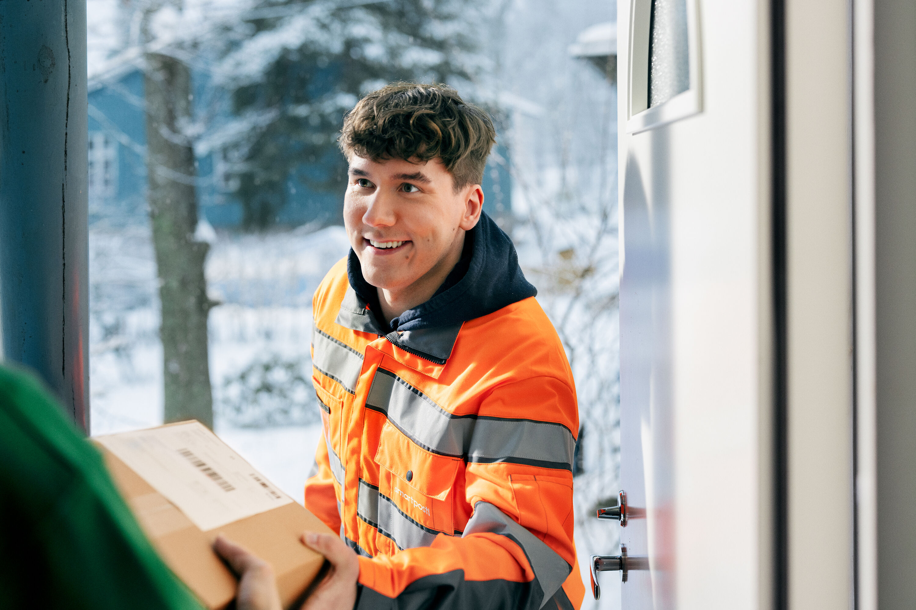 A SmartPosti worker delivering a package to a door.