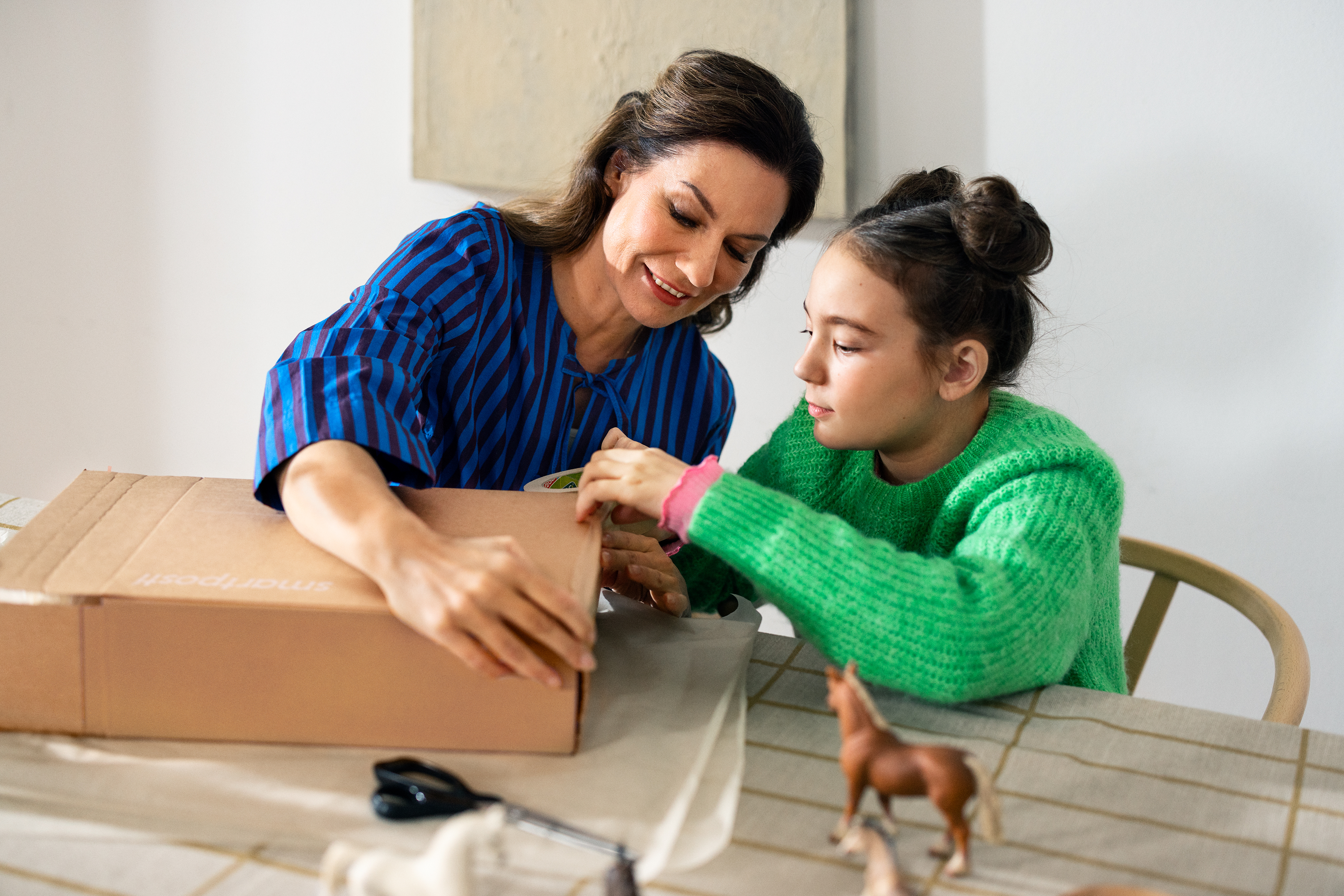 Mother and daughter packing a parcel