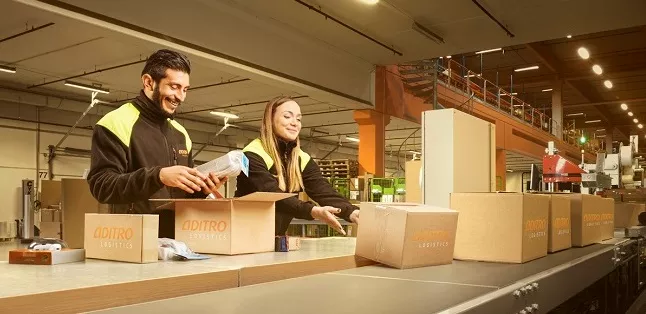 A woman and a man are packing parcels.