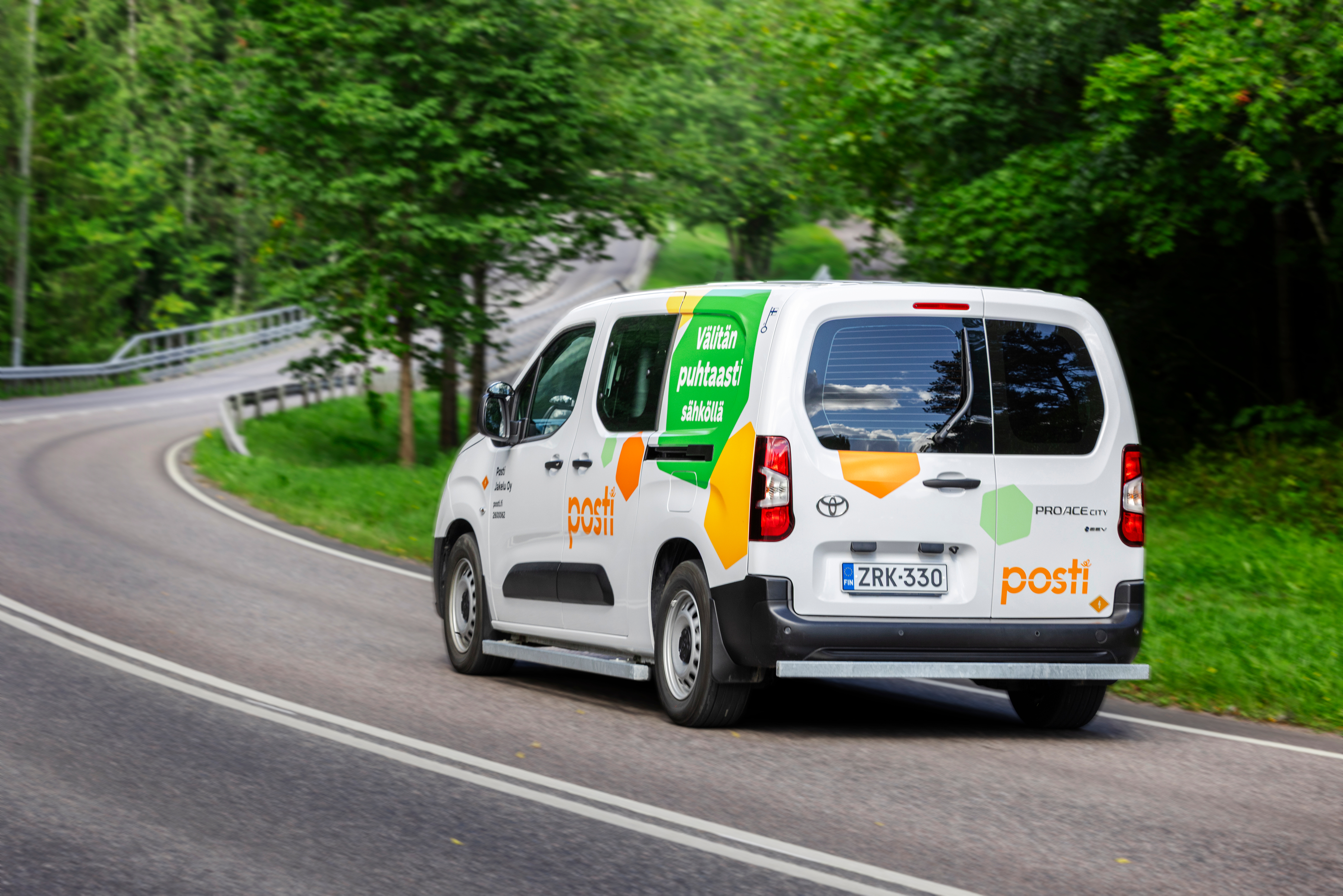 Posti delivery van driving on a forest road
