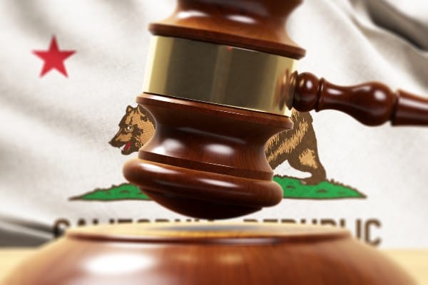 A gavel in front of the California state flag.