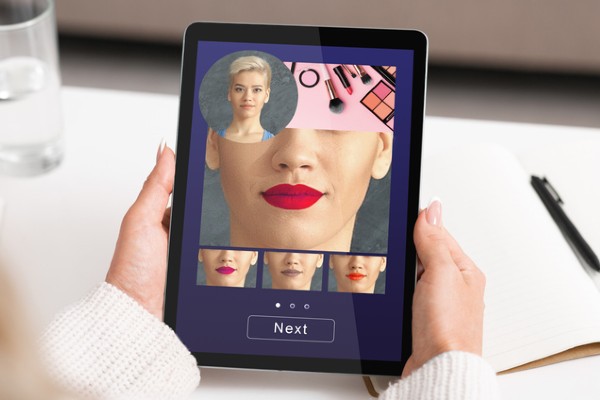 Tablet with woman trying different shades of lipstick