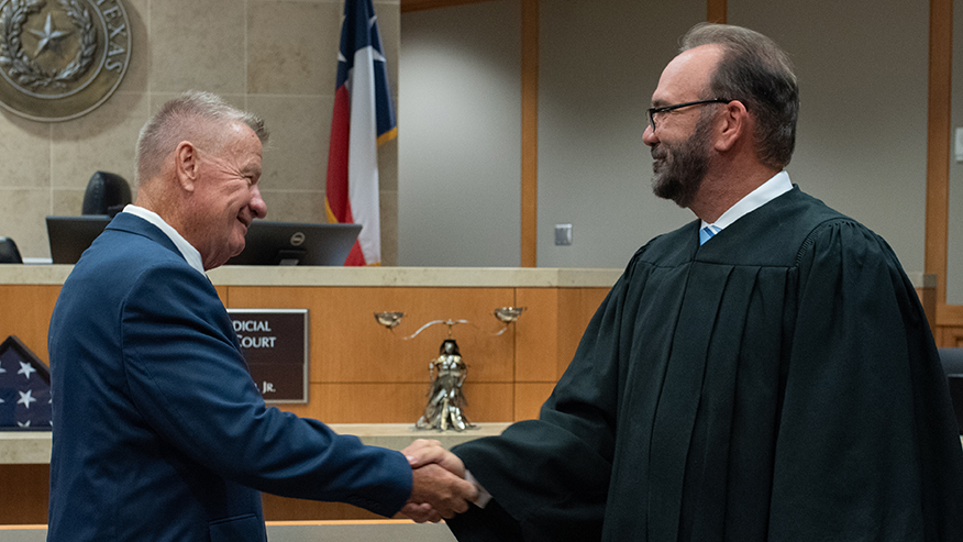 Nelson A. Locke shakes hands with Judge John Roach Jr. after being sworn in to the Texas state bar