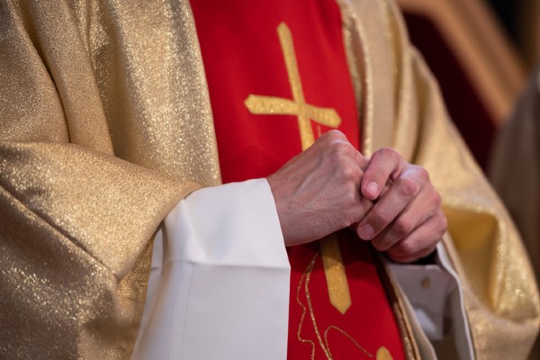 The Catholic Church is represented by the hands of a priest.