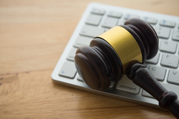 A judge's gavel on a computer keyboard, representing legal issues related to online activity.