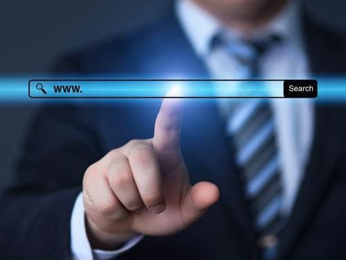Man in a suit pointing at a web search bar interface with "www ." typed in.