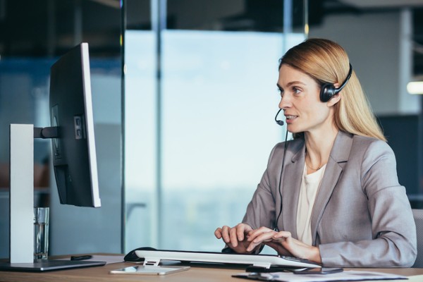 A female office worker records a meeting on her computer.