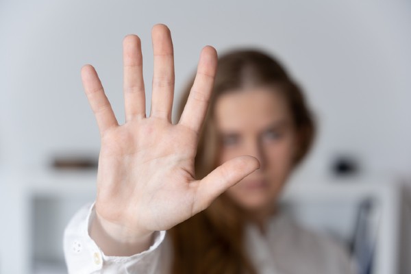 Woman with hand up in front of her face