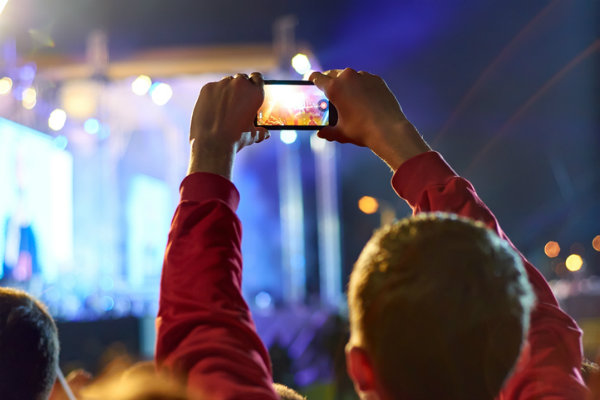 A man records a performer on his smartphone