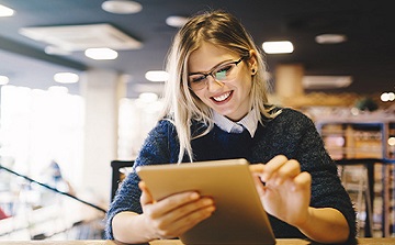 woman working on a tablet in a library