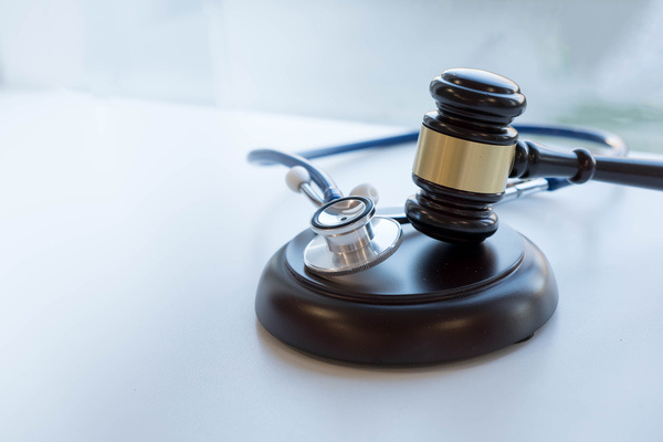 Gavel and stethoscope on desk symbolizing right-to-die legal issues.