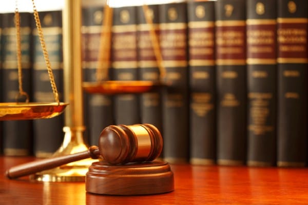 judge's gavel with scales and law books in the background