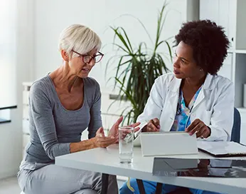 Middle aged woman talking to a doctor in ordination