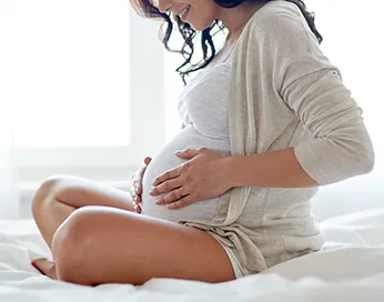 Pregnant woman holding hands on belly