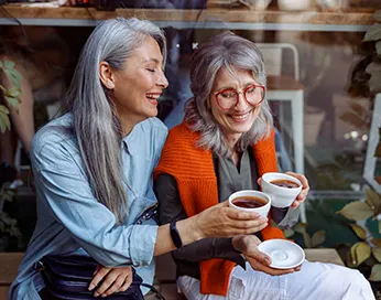 Two middle-aged women drinking tea