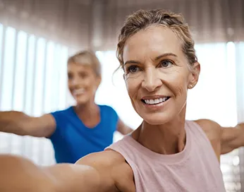 Smiling middle-aged woman doing exercise