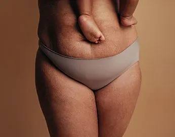 Belly of a woman holding a baby in her arms