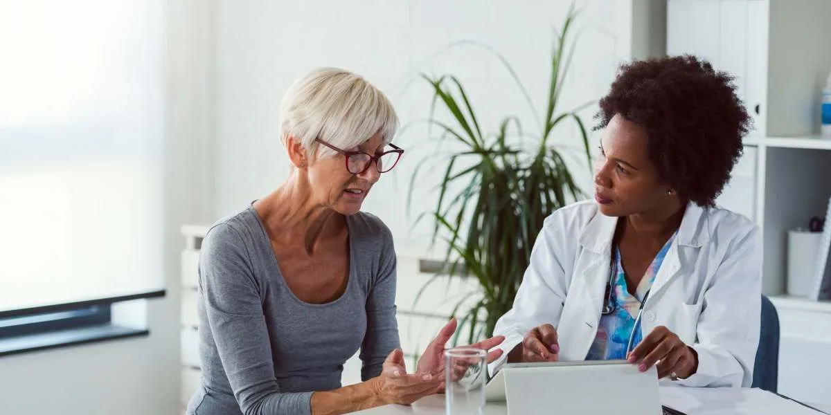 Middle aged woman talking to a doctor in ordination