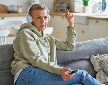 Middle-aged woman with headphones on her ears