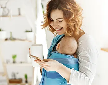 Smiling woman with a newborn baby in her arms