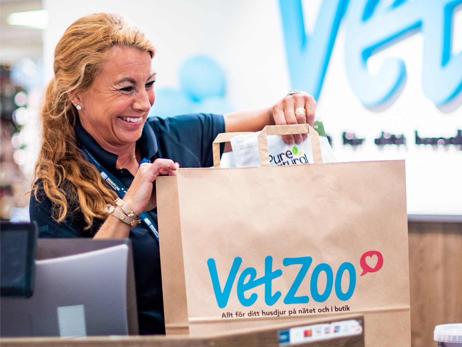 Kassörska packar en papperskasse från VetZoo