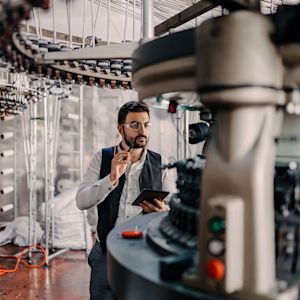 Man monitors machine with the help of a tablet