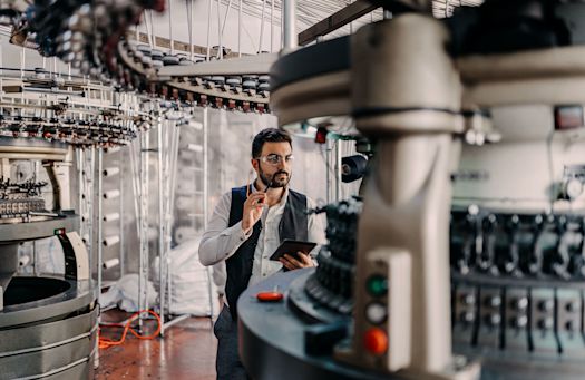 Man monitors machine with the help of a tablet