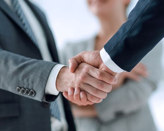 Handshake close-up between two men in suits