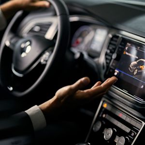 Man driving in car uses car display