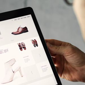 Man holding a tablet and browsing through an online shop