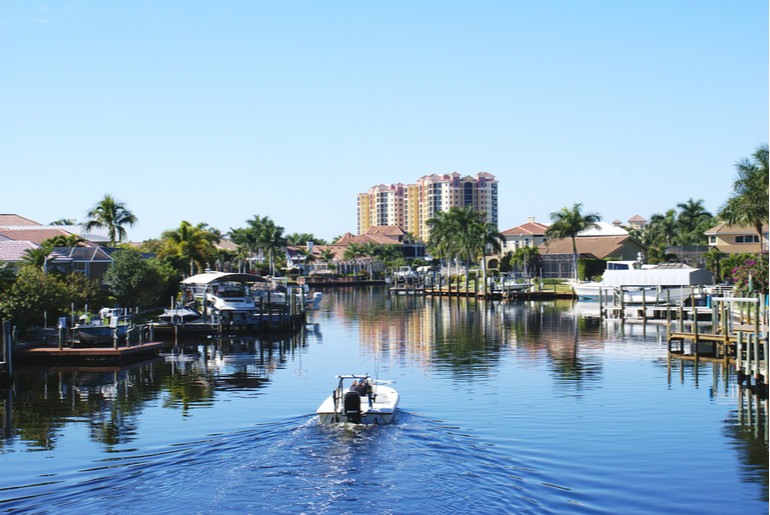 Boat going through a dockside community in Cape Coral, Florida