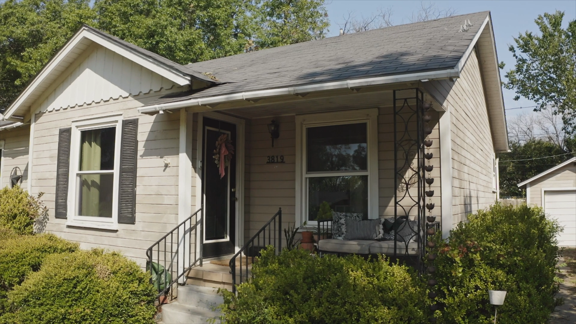 Front of home with wood siding, showcasing cracked boards and peeling paint