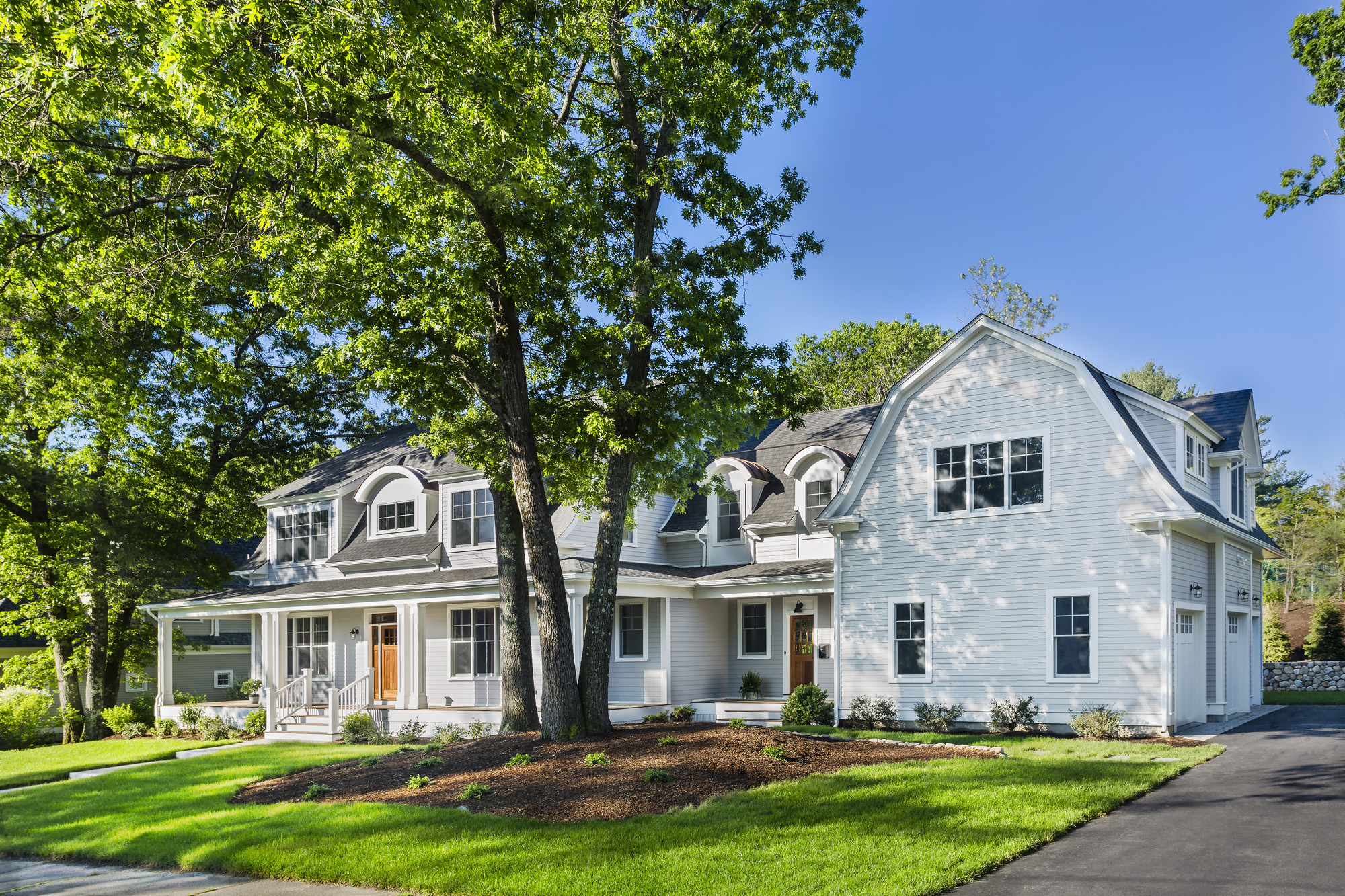 Dutch Colonial house clad in Light Mist Plank lap Hardie siding and Arctic White Hardie trim