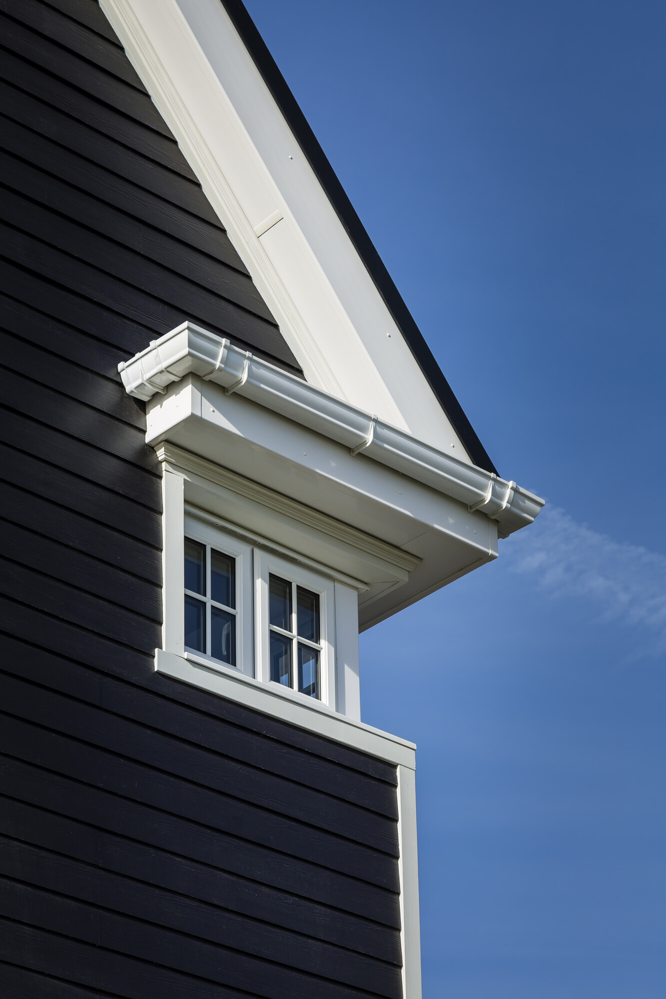 Detail of house with Midnight Black plank lap siding and Arctic White Hardie trim 
